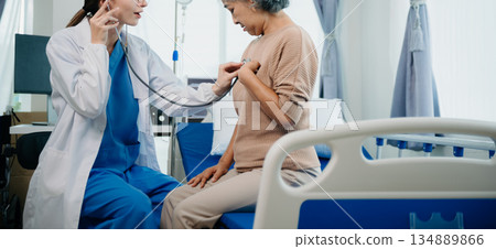 Caucasian doctor smiling take care of a young patient in hospital. Friendly nurse or therapeutic treat client Professional 134889866