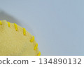 Close-up of yellow felt fabric and embroidery thread 134890132