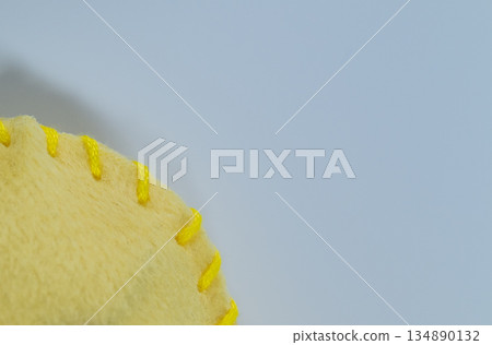 Close-up of yellow felt fabric and embroidery thread Close-up of yellow felt fabric and embroidery thread 134890132