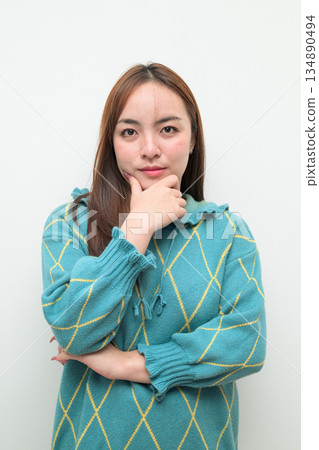 Portrait of a young Asian woman against white background thinking 134890494