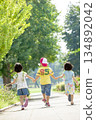 Rear view of three children playing in the park 134892042