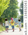 Rear view of three children playing in the park 134892043