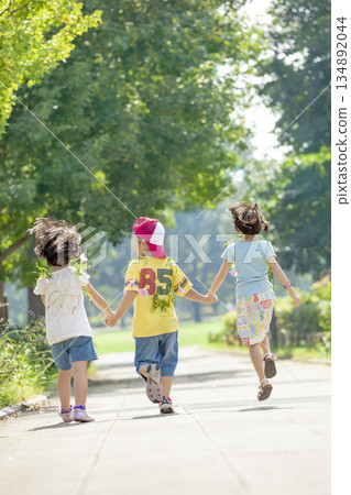 Rear view of three children playing in the park 134892044