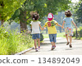 Rear view of three children playing in the park 134892049