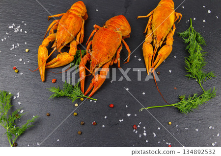 Red boiled crayfish with dill and spices on black slate background. Top view 134892532