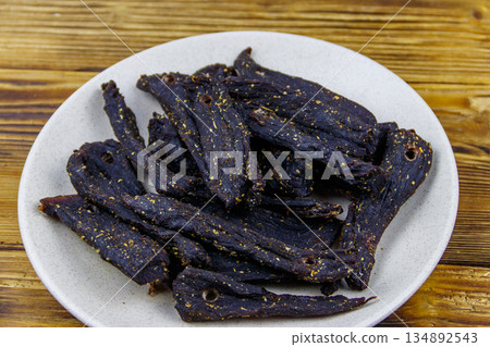 Slices of biltong (South African dried meat) on wooden table Slices of biltong (South African dried meat) on wooden table 134892543