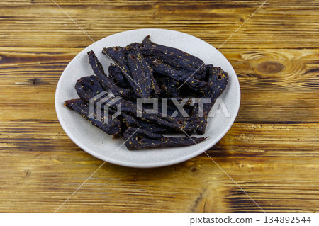 Slices of biltong (South African dried meat) on wooden table 134892544