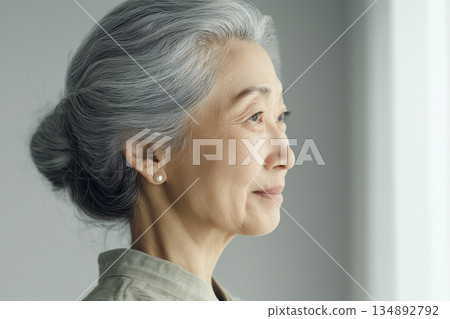 一位老年婦女凝視窗外的側臉 一位老年婦女凝視窗外的側臉 134892792