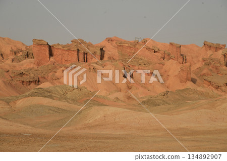 Kizil Red Stone Forest Scenic Area in Xinjiang , China is the strangely shaped red rock forests were carved by wind and sand over millions of years, giving them the appearance of abandoned cities. 134892907