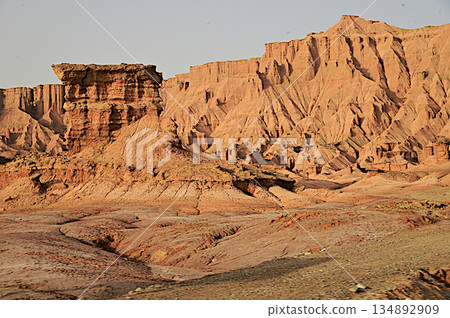 Kizil Red Stone Forest Scenic Area in Xinjiang , China is the strangely shaped red rock forests were carved by wind and sand over millions of years, giving them the appearance of abandoned cities. 134892909