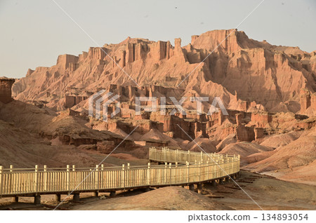Footpath bridge at Kizil Red Stone Forest Scenic Area in Xinjiang , China is the strangely shaped red rock forests were carved by wind and sand over millions of years. Footpath bridge at Kizil Red Stone Forest Scenic Area in Xinjiang , China is the strangely shaped red rock forests were carved by wind and sand over millions of years. 134893054