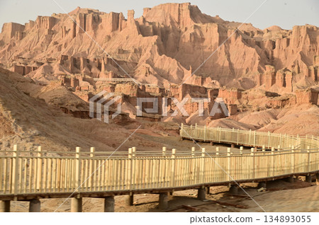 Footpath bridge at Kizil Red Stone Forest Scenic Area in Xinjiang , China is the strangely shaped red rock forests were carved by wind and sand over millions of years. Footpath bridge at Kizil Red Stone Forest Scenic Area in Xinjiang , China is the strangely shaped red rock forests were carved by wind and sand over millions of years. 134893055