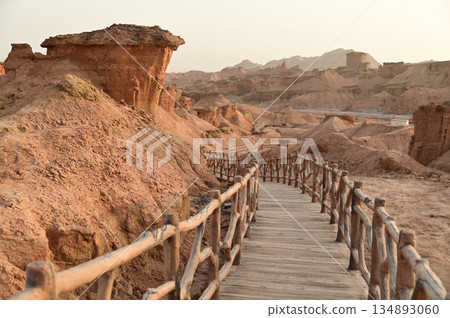 Footpath bridge at Kizil Red Stone Forest Scenic Area in Xinjiang , China is the strangely shaped red rock forests were carved by wind and sand over millions of years. Footpath bridge at Kizil Red Stone Forest Scenic Area in Xinjiang , China is the strangely shaped red rock forests were carved by wind and sand over millions of years. 134893060
