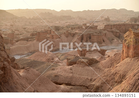 Kizil Red Stone Forest Scenic Area in Xinjiang , China is the strangely shaped red rock forests were carved by wind and sand over millions of years, giving them the appearance of abandoned cities. 134893151