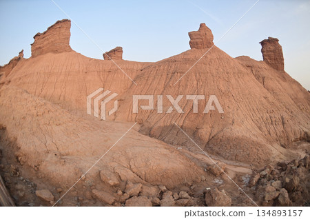 Kizil Red Stone Forest Scenic Area in Xinjiang , China is the strangely shaped red rock forests were carved by wind and sand over millions of years, giving them the appearance of abandoned cities. 134893157