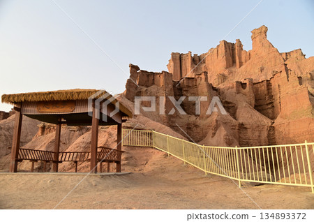 Pavilion at Kizil Red Stone Forest Scenic Area in Xinjiang , China is the strangely shaped red rock forests were carved by wind and sand over millions of years. Pavilion at Kizil Red Stone Forest Scenic Area in Xinjiang , China is the strangely shaped red rock forests were carved by wind and sand over millions of years. 134893372