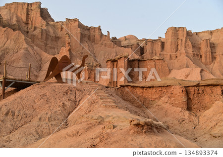 Kizil Red Stone Forest Scenic Area in Xinjiang , China is the strangely shaped red rock forests were carved by wind and sand over millions of years, giving them the appearance of abandoned cities.  134893374