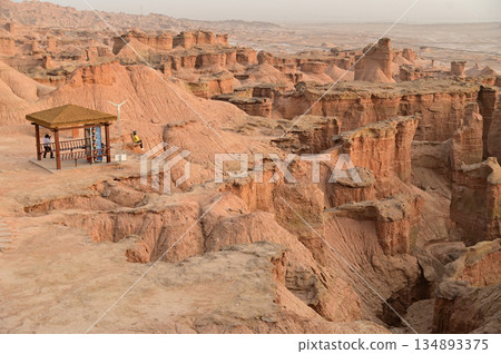 Kizil Red Stone Forest Scenic Area in Xinjiang , China is the strangely shaped red rock forests were carved by wind and sand over millions of years, giving them the appearance of abandoned cities.  134893375