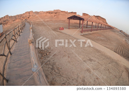 Footpath bridge at Kizil Red Stone Forest Scenic Area in Xinjiang , China is the strangely shaped red rock forests were carved by wind and sand over millions of years. The rocks are red in color. 134893380