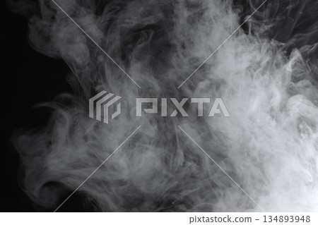 Abstract white smoke and fog drifting on dark black background with ample copy space, atmospheric texture for overlays and design Abstract white smoke and fog drifting on dark black background with ample copy space, atmospheric texture for overlays and design 134893948