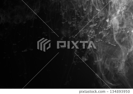 Abstract white smoke and fog drifting on dark black background with ample copy space, atmospheric texture for overlays and design 134893950