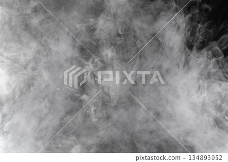 Abstract white smoke and fog drifting on dark black background with ample copy space, atmospheric texture for overlays and design 134893952