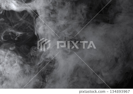 Abstract white smoke and fog drifting on dark black background with ample copy space, atmospheric texture for overlays and design 134893967
