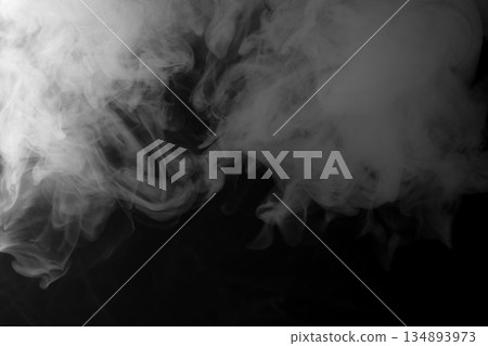 Abstract white smoke and fog drifting on dark black background with ample copy space, atmospheric texture for overlays and design Abstract white smoke and fog drifting on dark black background with ample copy space, atmospheric texture for overlays and design 134893973