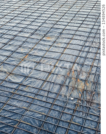 Steel reinforcement grid laid on a concrete surface for construction. Steel reinforcement grid laid on a concrete surface for construction. 134894526