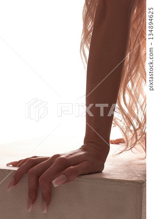Elegant female hand with French manicure and blonde hair on white background 134894625