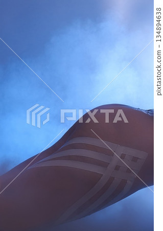 Sensual close-up of a female body with tape in blue neon lighting Sensual close-up of a female body with tape in blue neon lighting 134894638