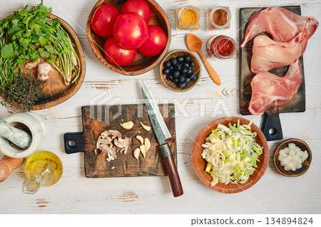 Preparing fresh ingredients for cooking in a kitchen setting with various foods and tools Preparing fresh ingredients for cooking in a kitchen setting with various foods and tools 134894824