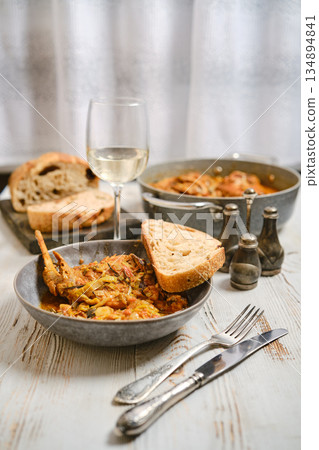 Table setup with food, drink, and bread ready for dinner in a cozy indoor setting 134894841