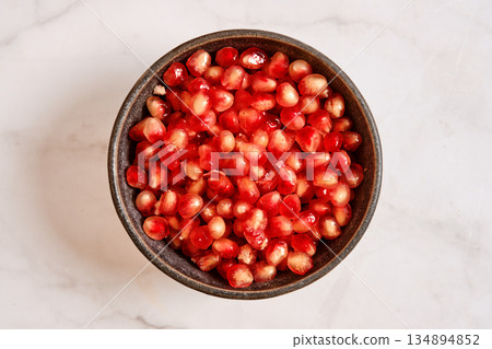 Pomegranate seeds in a bowl ready for cooking or eating at home 134894852