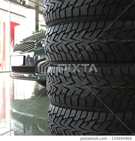 Set of new winter tires stacked for sale in car parts shop Set of new winter tires stacked for sale in car parts shop 134894968
