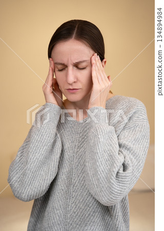 Sad Caucasian woman holding her head closing eyes in pain, touch forehead, feels stress, frustration. Worry due to work pressure, overwhelming tasks or deadlines, feel headache. Information overload Sad Caucasian woman holding her head closing eyes in pain, touch forehead, feels stress, frustration. Worry due to work pressure, overwhelming tasks or deadlines, feel headache. Information overload 134894984
