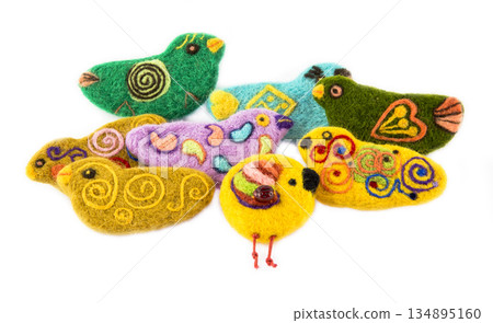 Brooch of fulled wool in the form of birds on a white background 134895160