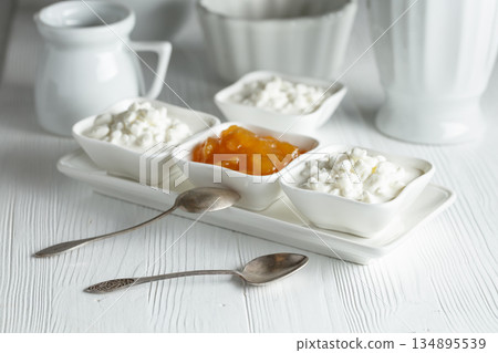 Cottage cheese with cream and yellow jam. Cottage cheese with cream and yellow jam. 134895539