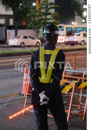 Night Road Worker Directing Traffic Safely Night Road Worker Directing Traffic Safely 134895587