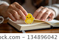 The beginning of the Year of the Rooster. A woman's hand sticks cute chick-patterned stickers on her diary. 134896042