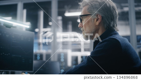 Mature Manager in Formal Attire and Glasses Using Workstation in High Security Modern Data Center Mature Manager in Formal Attire and Glasses Using Workstation in High Security Modern Data Center 134896868