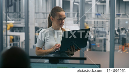 Woman Monitoring Automated Systems on Laptop Woman Monitoring Automated Systems on Laptop 134896961