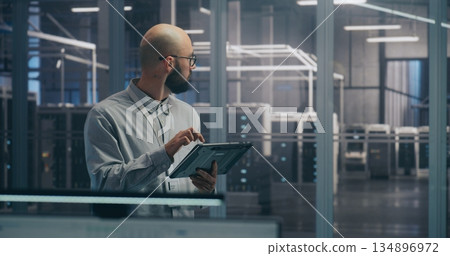 On Site Coordination, IT Specialist Using Tablet to Diagnose Rack Status 134896972