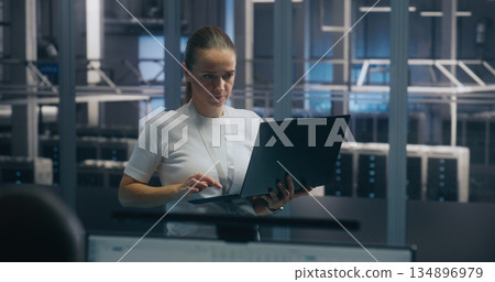 Experienced Female Engineer Uses Portable PC Run Diagnostics Performance Metrics 134896979
