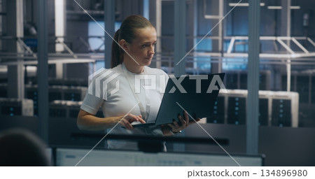 Experienced Female Engineer Uses Portable PC Run Diagnostics Performance Metrics Experienced Female Engineer Uses Portable PC Run Diagnostics Performance Metrics 134896980