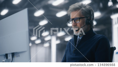 Male IT Consultant Participating in Video Call Using Headset and Microphone in High Tech Facility 134896988