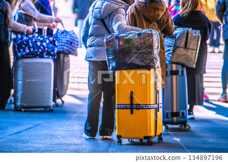 Tokyo cityscape, Japan, New Year's Day. Inbound tourism continues... suitcases... Foreign tourists waiting at the traffic light in front of Ueno Station Tokyo cityscape, Japan, New Year's Day. Inbound tourism continues... suitcases... Foreign tourists waiting at the traffic light in front of Ueno Station 134897196