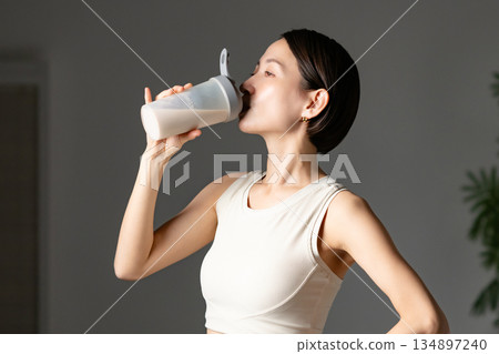  Woman drinking protein 134897240