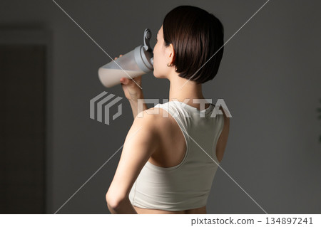  Woman drinking protein 134897241