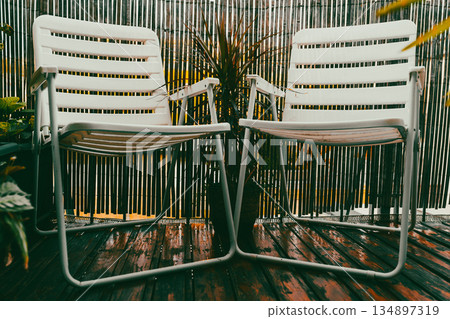 Garden white plastic chairs on terrace with mini balcony garden Garden white plastic chairs on terrace with mini balcony garden 134897319